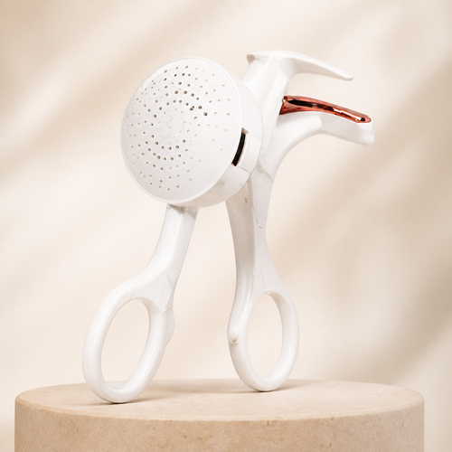 GlowWell Frameless Heated Eyelash Curler premium product hero on warm ivory studio background